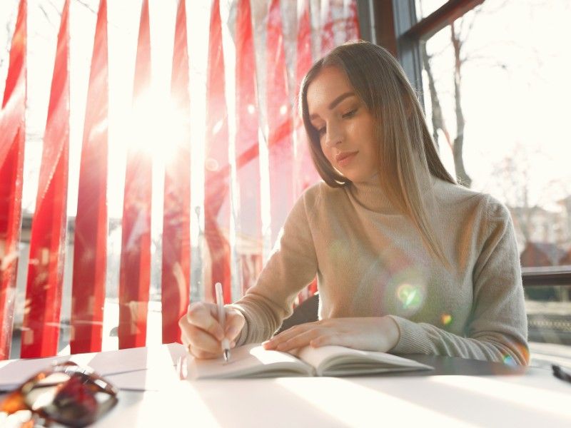 French language learner studying vocabulary and grammar independently with notebook